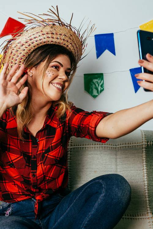 mulher vestida à moda festa junina tirando uma selfie